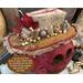 The custom made hat the gourd character is wearing is burlap with mustard yellow calico. Real acorns and dried botanicals trim out the hat